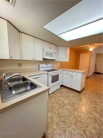 a kitchen with a sink a stove and cabinets