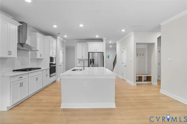 a large kitchen with stainless steel appliances kitchen island a large counter top and a stove top oven