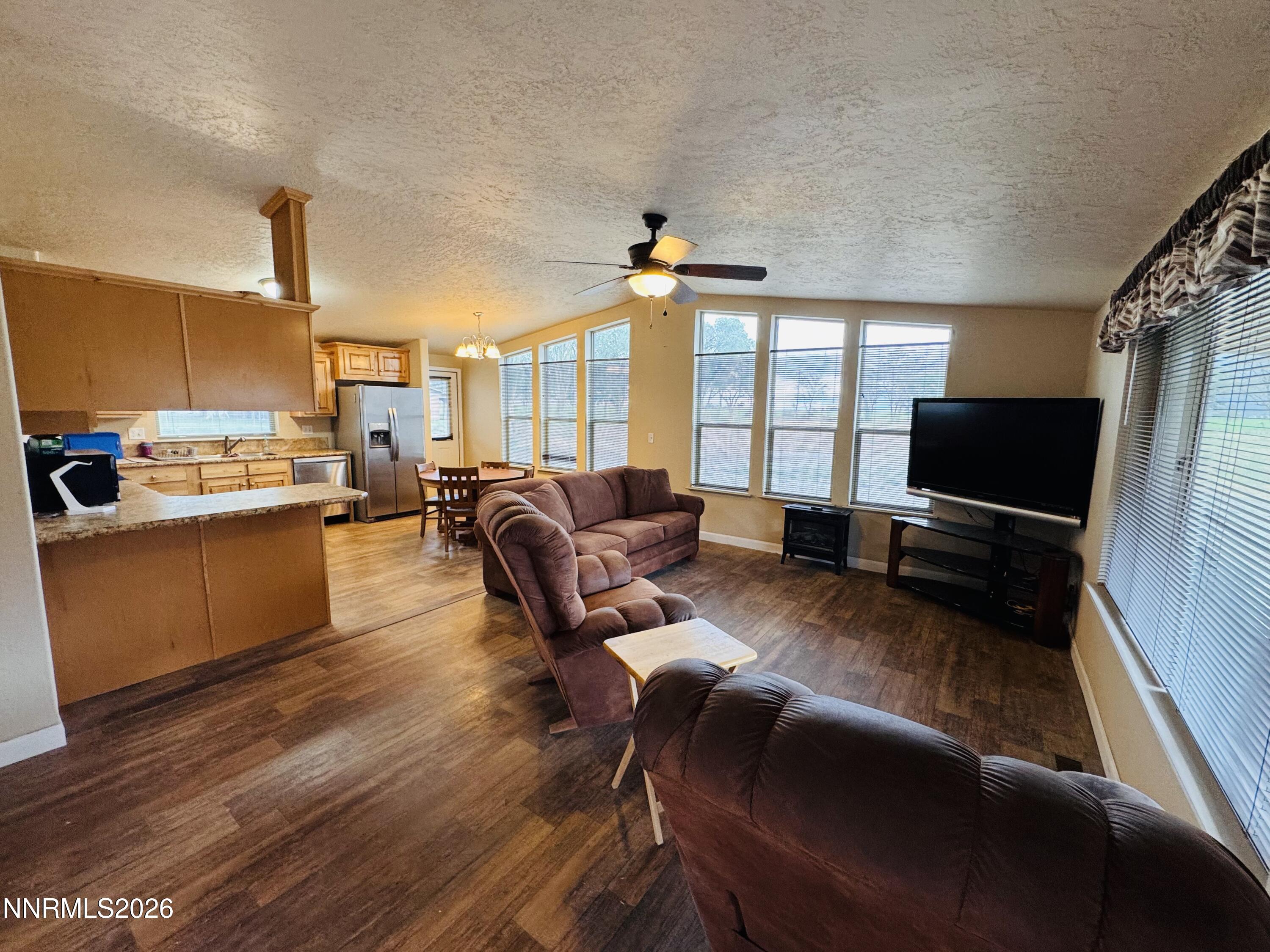 29400 Kings River Road Orovada, NV 89425 - Photo 10 of 40 a living room with furniture a flat screen tv and a floor to ceiling window
