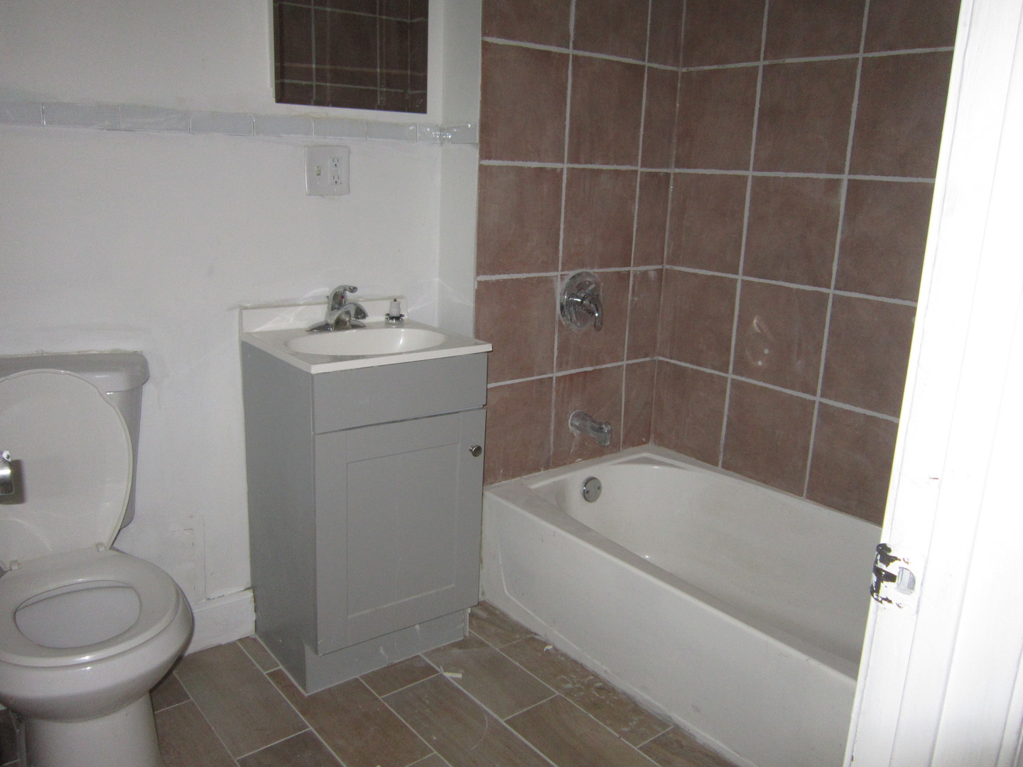 4035 West Harrison Street, Unit 1 Chicago, IL 60624 - Photo 8 of 12 a white bath tub sitting next to a white toilet