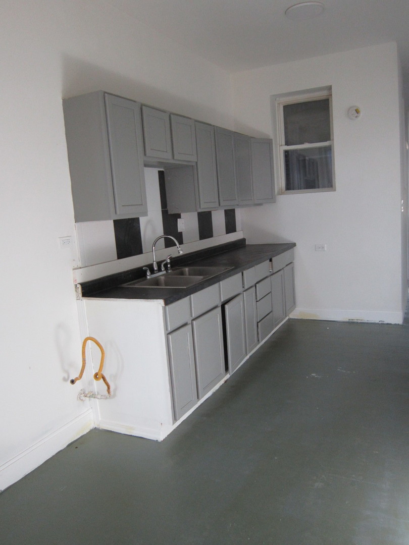 4035 West Harrison Street, Unit 1 Chicago, IL 60624 - Photo 9 of 12 a kitchen with a sink and a stove