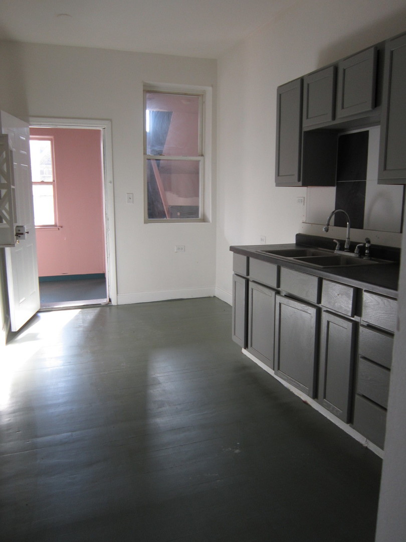 4035 West Harrison Street, Unit 1 Chicago, IL 60624 - Photo 10 of 12 a kitchen with stainless steel appliances a stove refrigerator sink and cabinets