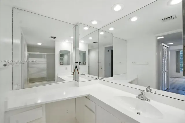 a bathroom with a sink shower and a mirror