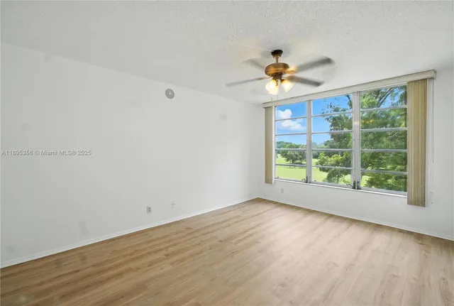 a view of a room with a wooden floor and a ceiling fan