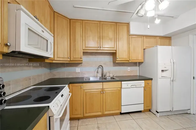 a kitchen with a sink a refrigerator and cabinets