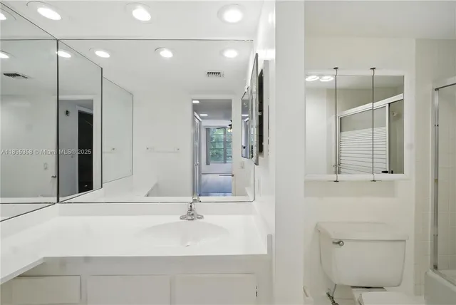 a bathroom with a sink a toilet and shower