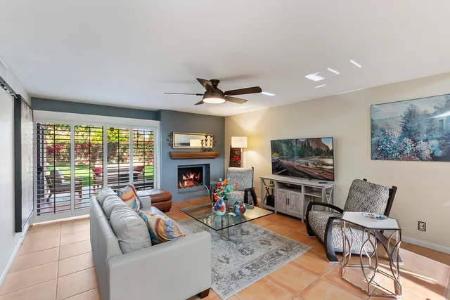 a living room with furniture a fireplace and a flat screen tv
