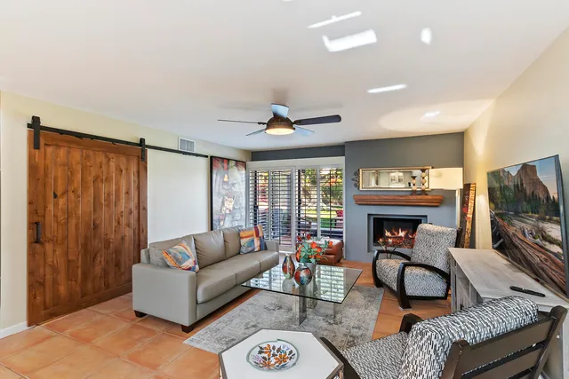 a living room with furniture a fireplace and a flat screen tv
