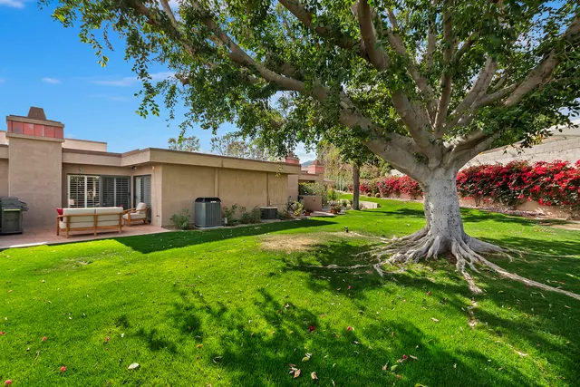 a view of a house with backyard and sitting area
