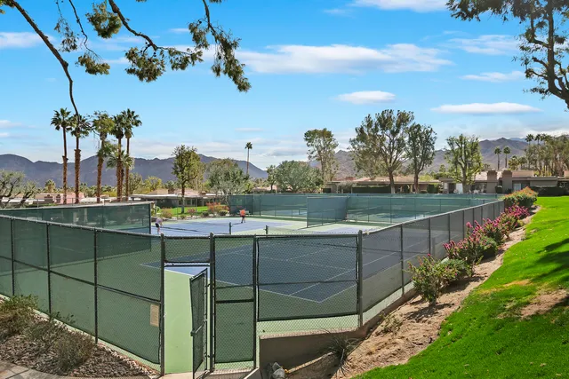 a view of a swimming pool with a lawn chairs under an umbrella