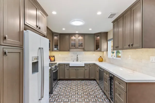 a kitchen with stainless steel appliances granite countertop a sink stove and refrigerator