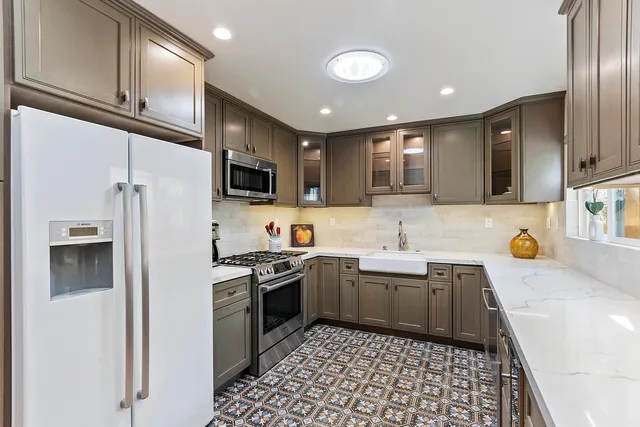 a kitchen with stainless steel appliances granite countertop a sink and stove top oven