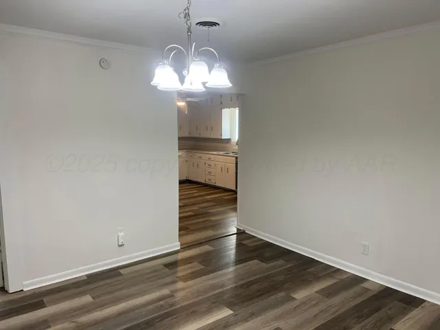 a view of a room with wooden floor and chandelier