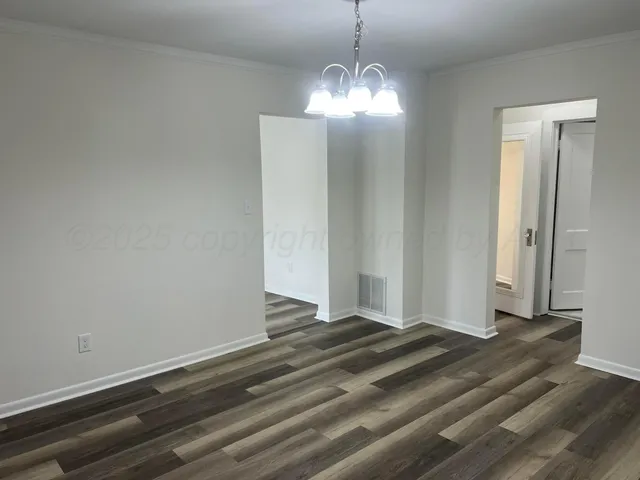 a view of a livingroom with wooden floor and chandelier