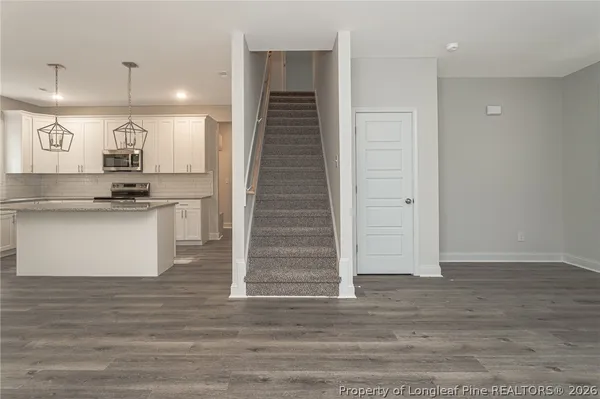 a kitchen with kitchen island a counter top space cabinets and stainless steel appliances