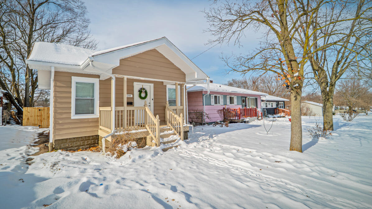 a front view of a house with a yard covered in snow