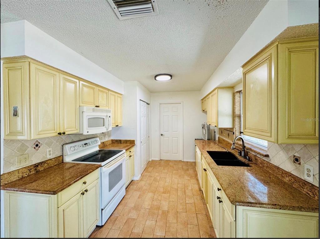 7423 Mohawk Trail Spring Hill, FL 34606 - Photo 16 of 20 a kitchen with a sink stove and cabinets