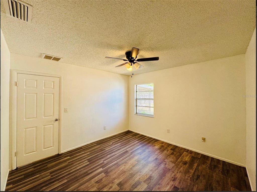 7423 Mohawk Trail Spring Hill, FL 34606 - Photo 9 of 20 a view of empty room with wooden floor and fan