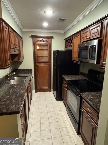 a kitchen with stainless steel appliances granite countertop a refrigerator stove and sink