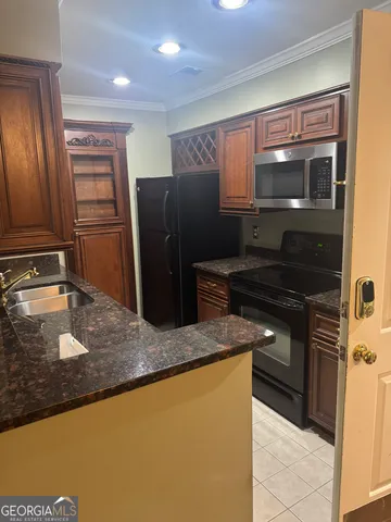 a kitchen with granite countertop a refrigerator and a sink
