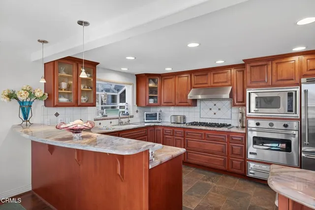 a kitchen with stainless steel appliances granite countertop a stove a sink and a refrigerator