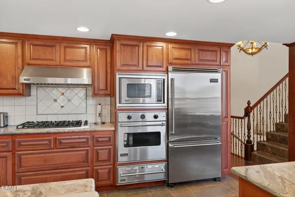 a kitchen with stainless steel appliances granite countertop a refrigerator and a stove