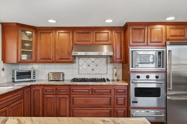 a kitchen with stainless steel appliances granite countertop a stove and cabinets