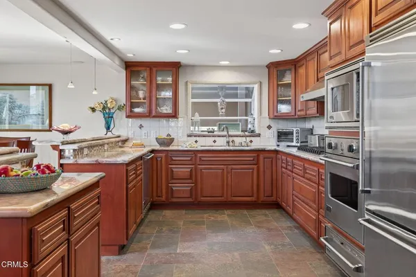 a kitchen with stainless steel appliances granite countertop a sink and cabinets