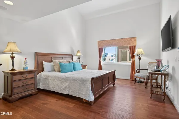 a bedroom with a bed and a flat tv screen on the dresser