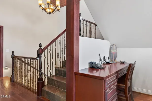 a view of staircase with lots of frames on wall and a window