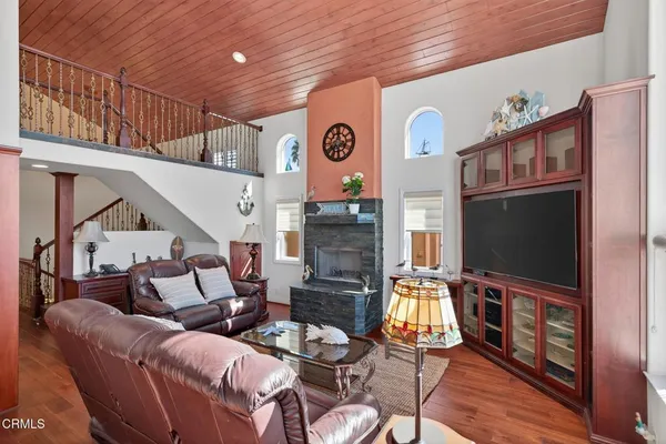 a living room with furniture a flat screen tv and kitchen view