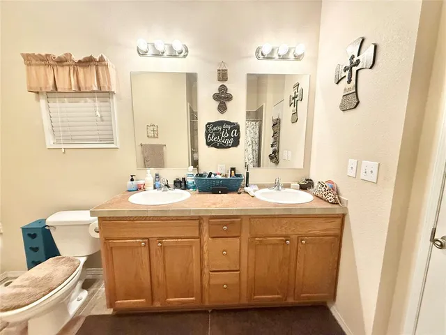 a bathroom with a granite countertop sink mirror vanity and toilet