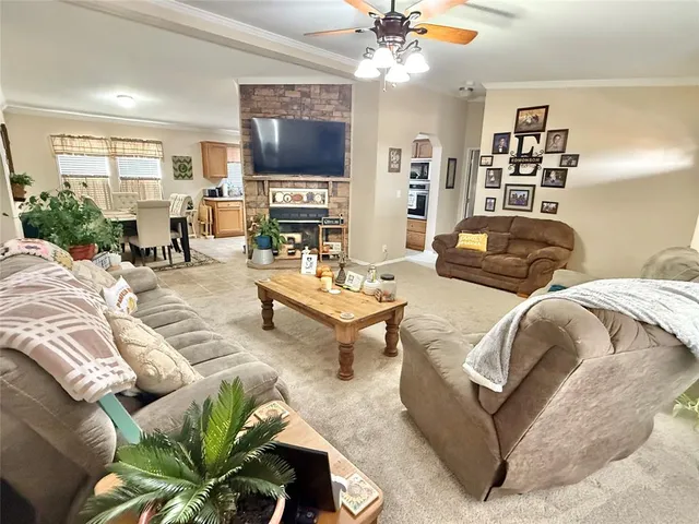a living room with furniture a chandelier and a flat screen tv