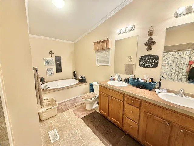 a spacious bathroom with a double vanity sink mirror and bathtub