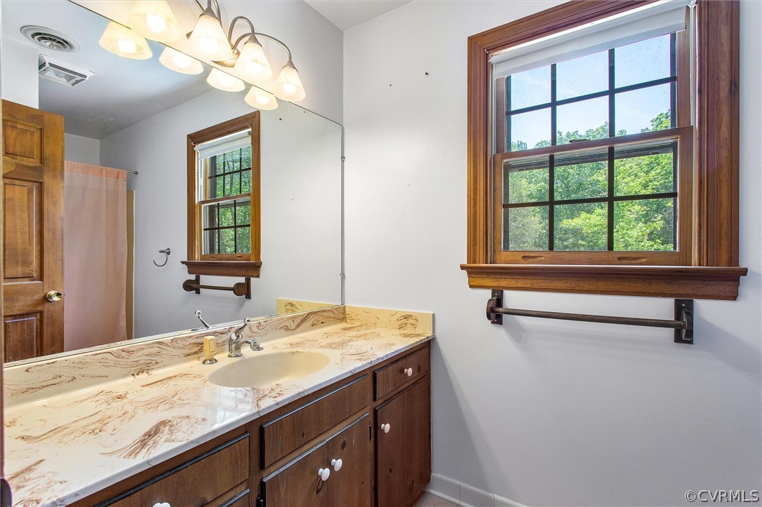 22601 Skinquarter Road Moseley, VA 23120 - Photo 31 of 50 a bathroom with a granite countertop sink a large mirror and a bathtub next to a window