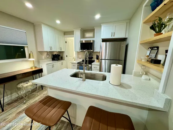 a kitchen with a sink a stove and chairs