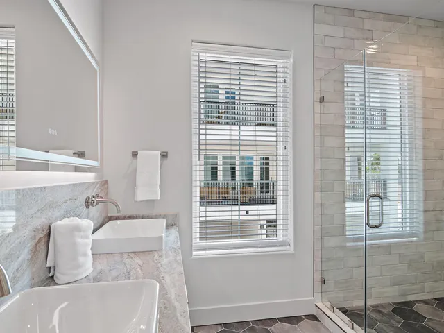 a bathroom with a granite countertop sink and a bathtub
