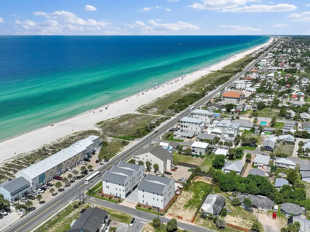 an aerial view of residential houses with outdoor space and parking