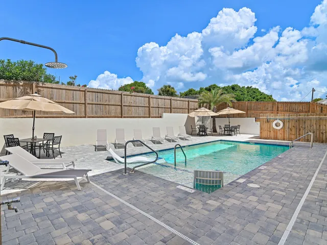 a view of a patio with a table and chairs under an umbrella