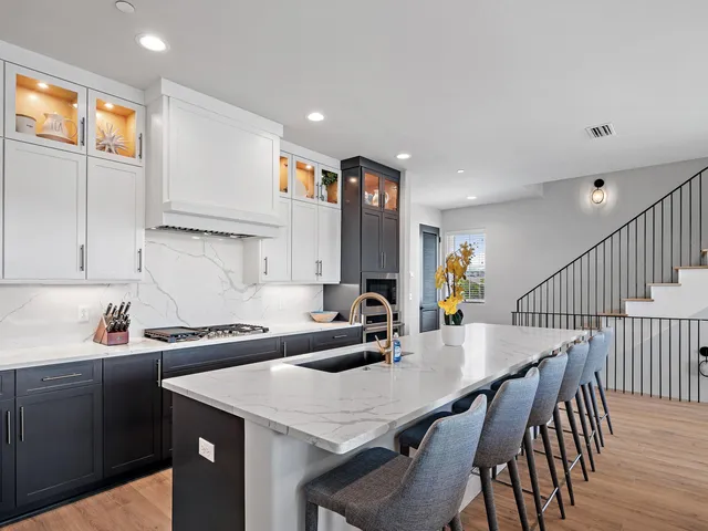 a kitchen with a dining table chairs and white cabinets