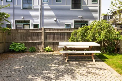 a view of backyard with a chair and potted plants