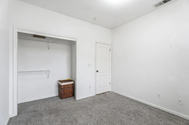 a bedroom with a bed and dresser with mirror