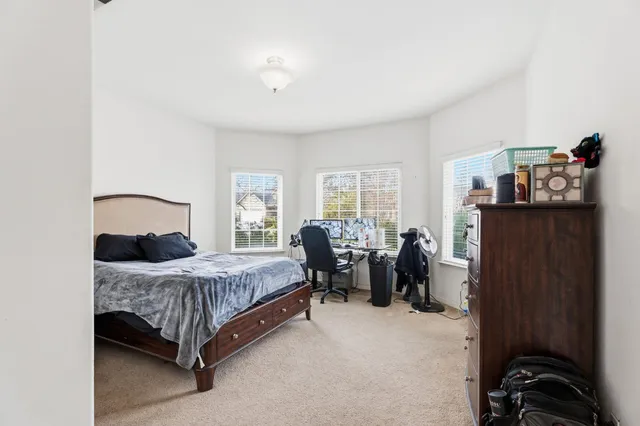 a bedroom with a bed gym equipment and a window