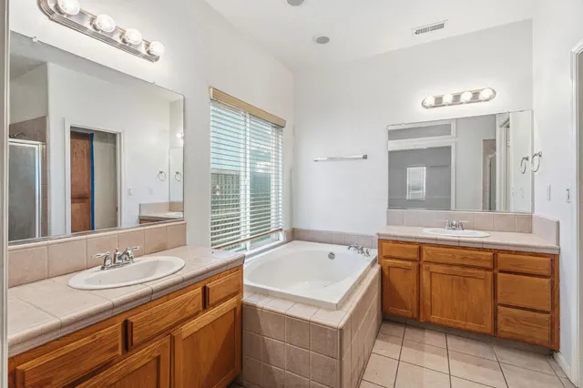 a bathroom with a tub sink and mirror