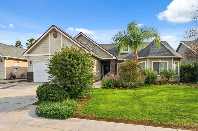 a view of a house with a yard and potted plants