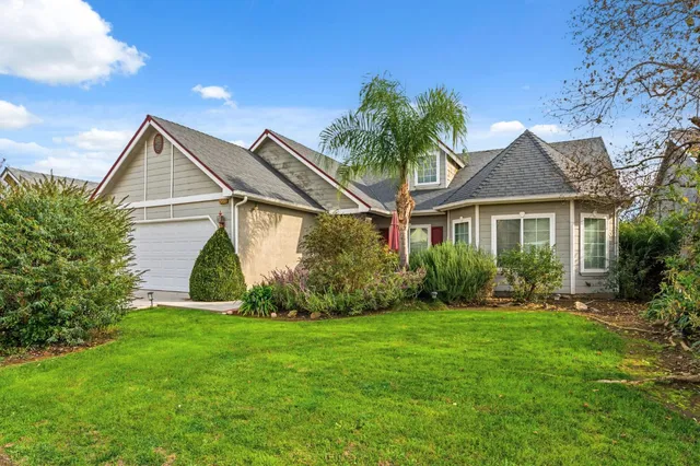 a front view of a house with a garden and plants