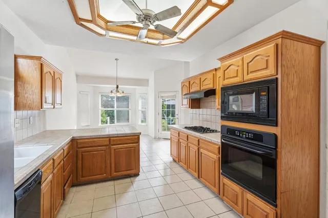 a kitchen with stainless steel appliances a stove a sink and a refrigerator