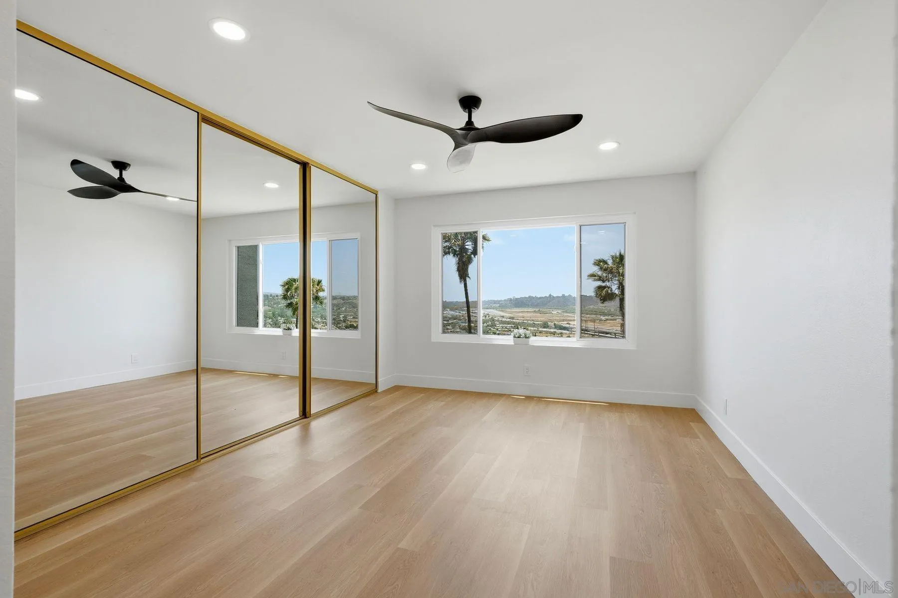 3606 Vista Rey, Unit 46 Oceanside, CA 92057 - Photo 17 of 36 a view of an empty room with a window and wooden floor