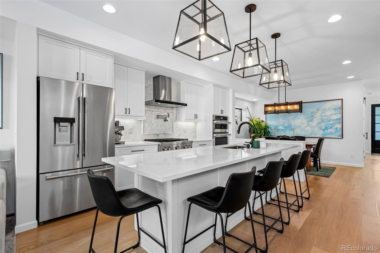 3451 Quivas Street Denver, CO 80211 - Photo 14 of 50 a kitchen with stainless steel appliances a table chairs and refrigerator