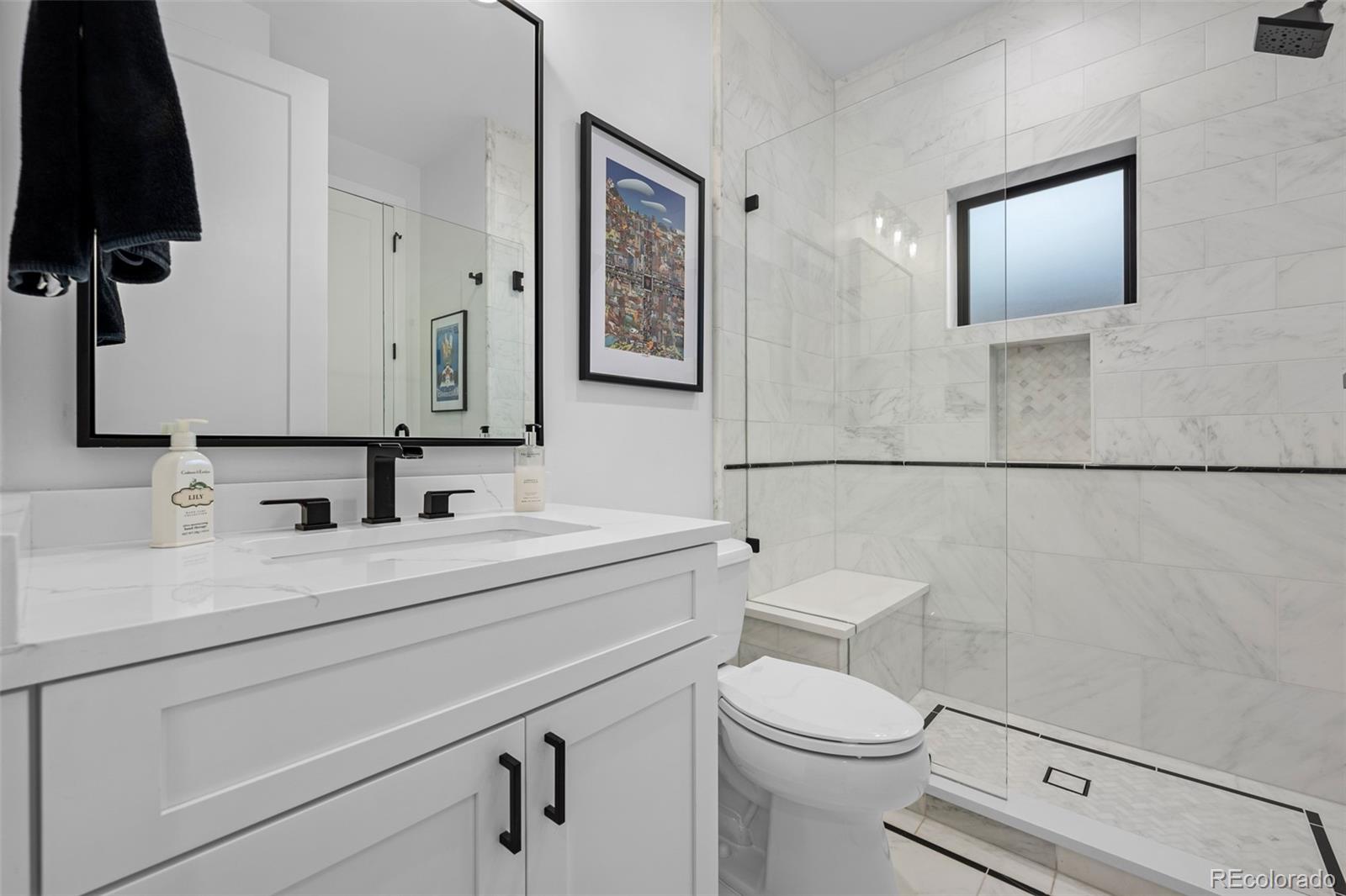 3451 Quivas Street Denver, CO 80211 - Photo 18 of 50 a bathroom with a toilet a sink and mirror